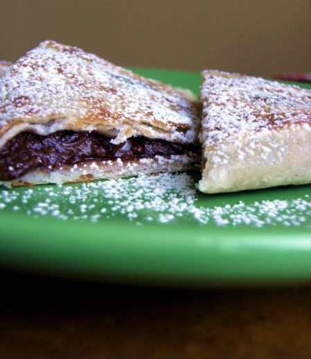 two pastries on a green plate with powdered sugar