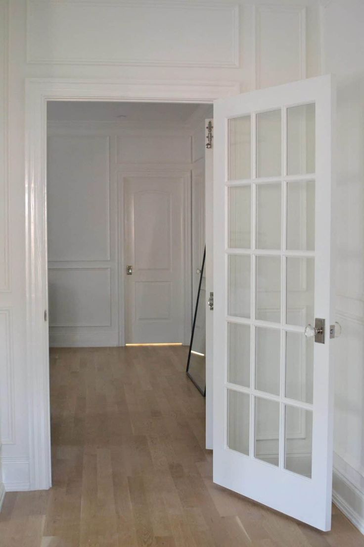 an empty hallway with white walls and wooden floors