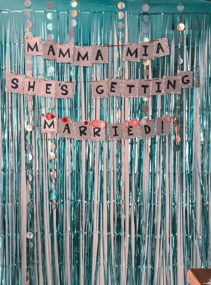 a party backdrop with the words mamma she's getting married and streamers