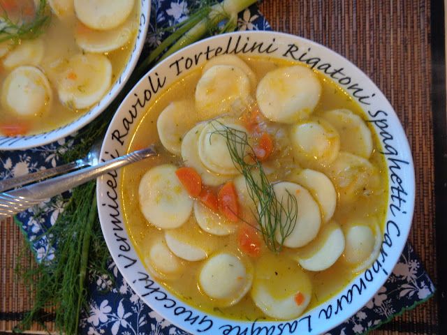 two bowls of vegetable tortellini soup on a table