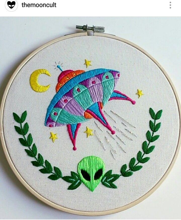 an embroidered wall hanging with a space ship on it