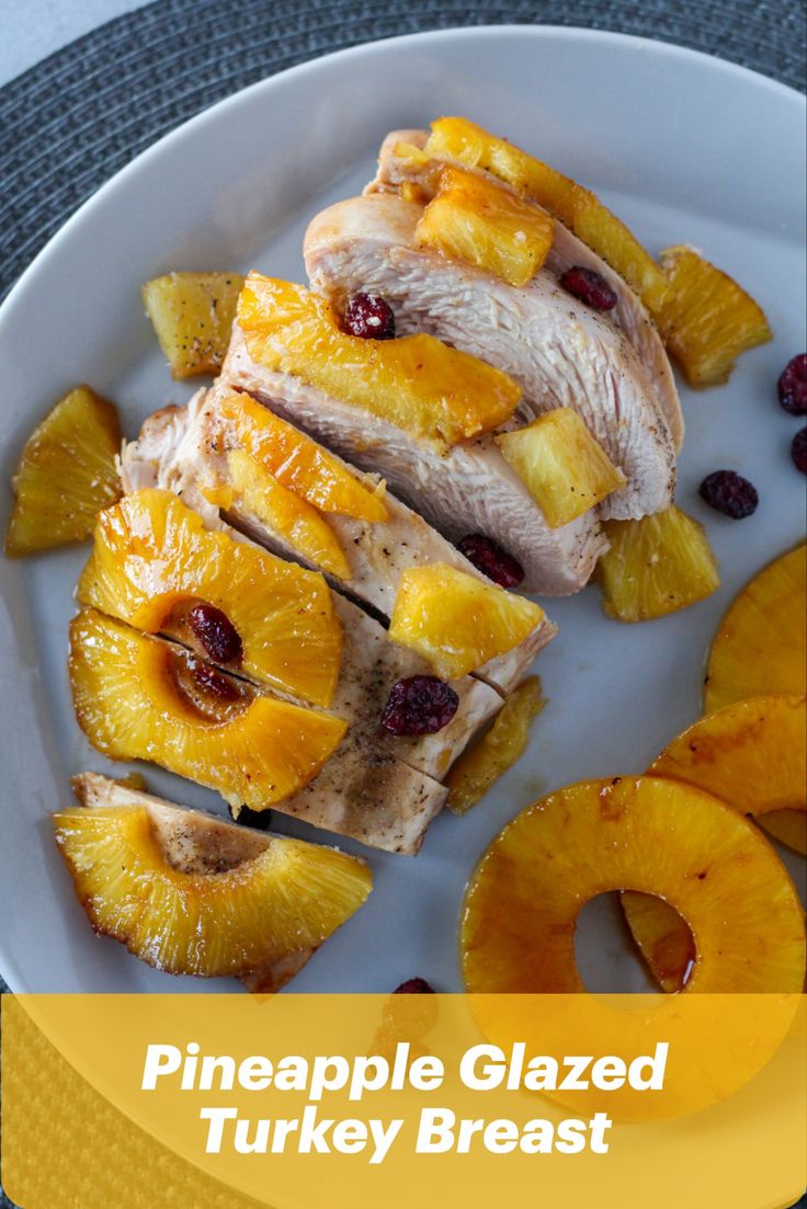 pineapple glazed turkey breast with cranberry sauce on a white plate next to sliced pineapples