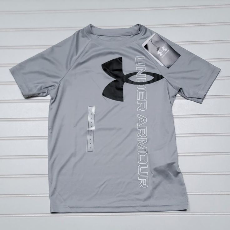 Nwt Under Armour Athletic T-Shirt, Size Ysm, Gray With Black And White Logo. Under Armour Graphic Print Tops For Streetwear, Under Armour Crew Neck Top With Letter Print, Sporty Under Armour Tops With Letter Print, Under Armour Sporty Tops With Letter Print, Under Armour Gray Crew Neck Top, Under Armour Sporty T-shirt With Letter Print, Under Armour Moisture-wicking Tops For Streetwear, Under Armour White T-shirt With Graphic Print, Under Armour Short Sleeve T-shirt With Letter Print