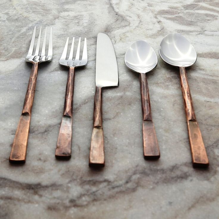 five different types of spoons and forks on a marble counter top with silverware