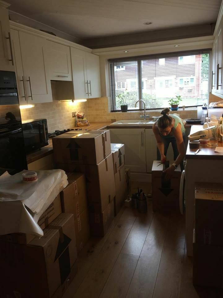 a man standing on top of boxes in a kitchen