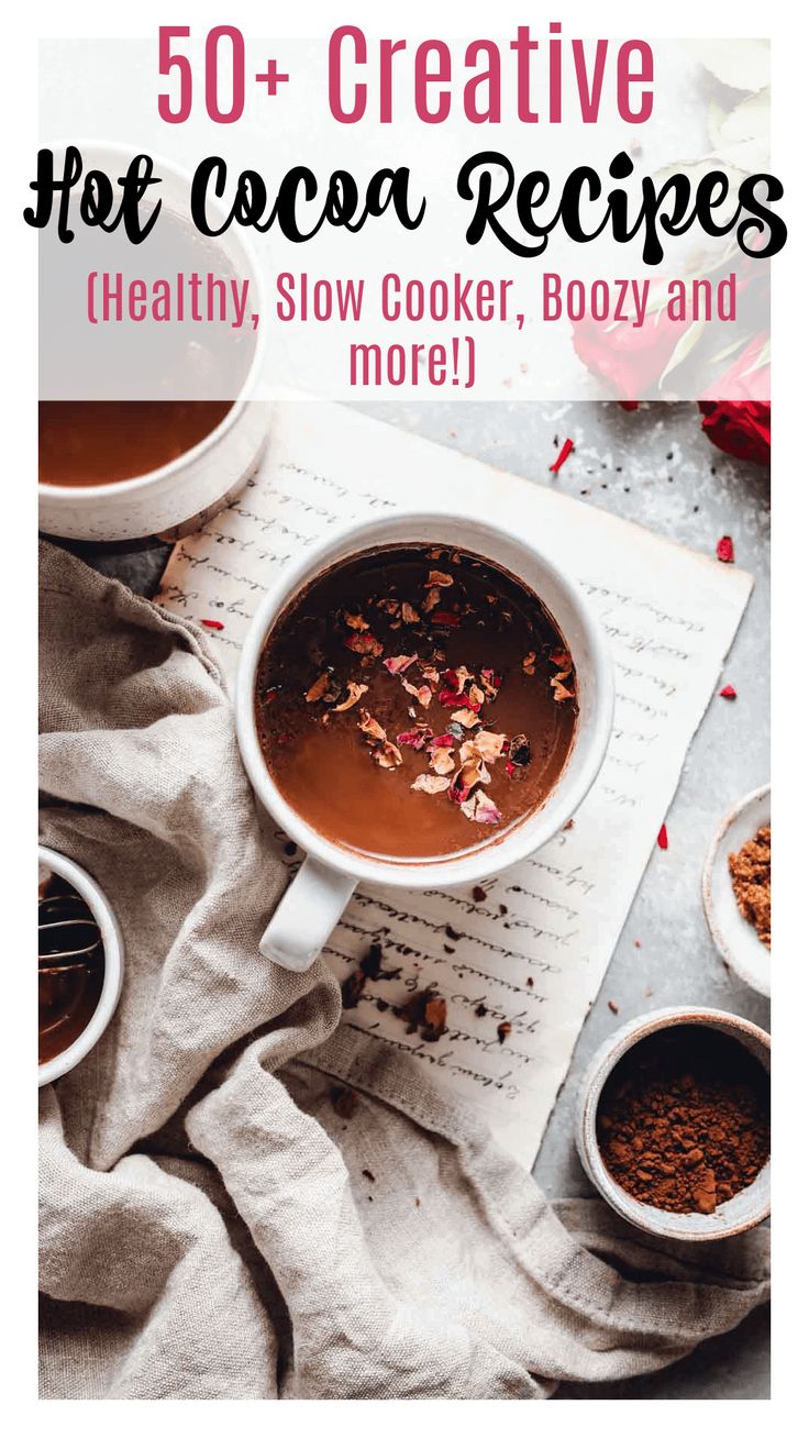 a cup of hot cocoa sits on top of a table next to two cups of coffee