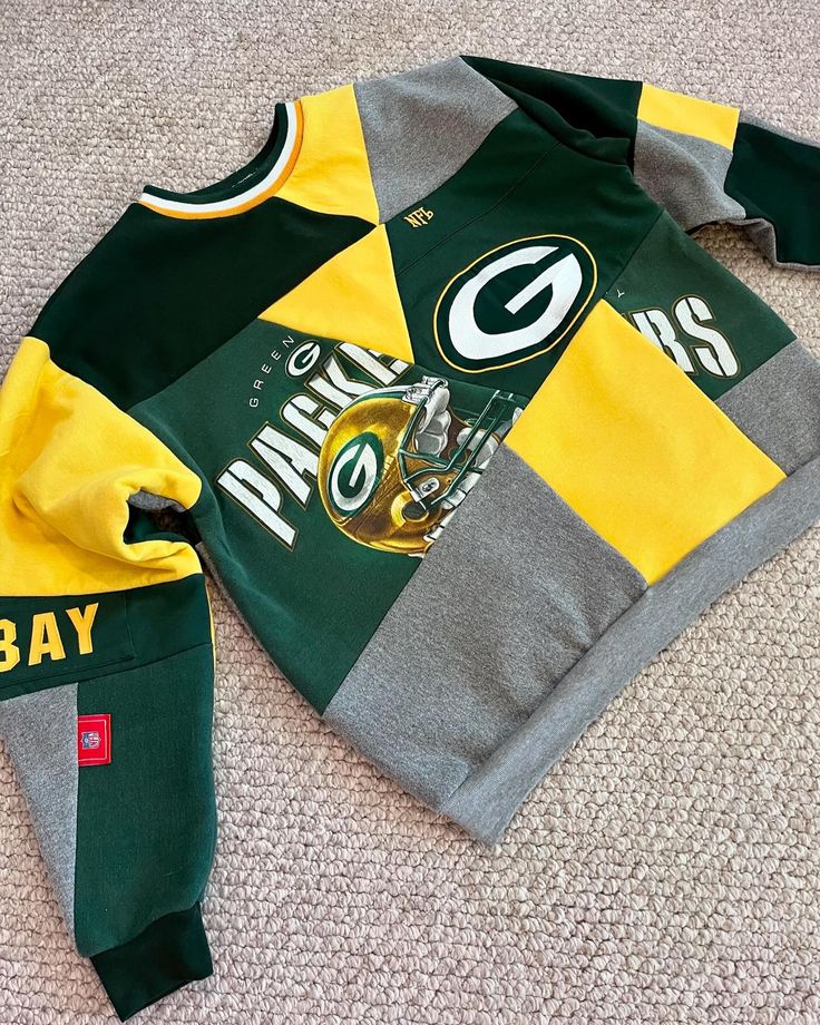 the green bay packers jersey is laying on the floor next to it's hoodie