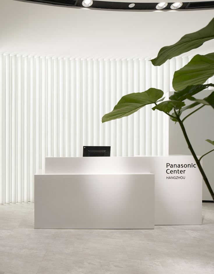 a white counter with a plant in front of it that says panasonic center