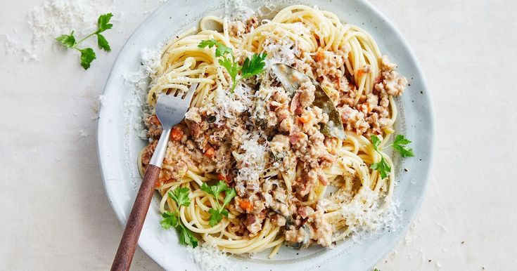 a plate of pasta with meat and parmesan cheese