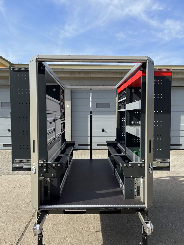 the back end of a truck with its doors open and shelves on it's side