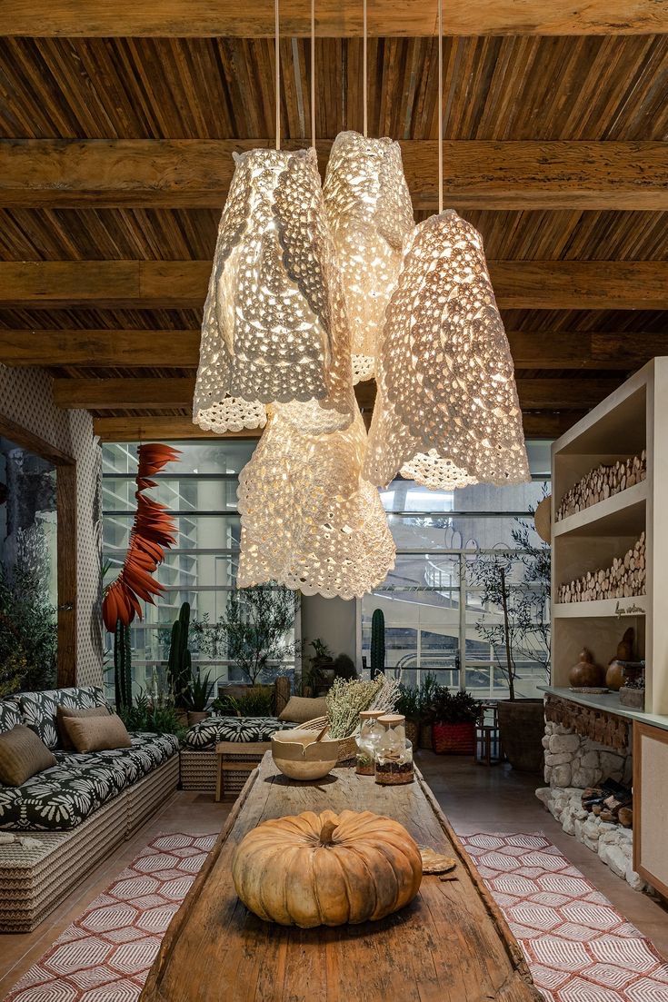 a large wooden table topped with lots of lights hanging from it's ceiling beams