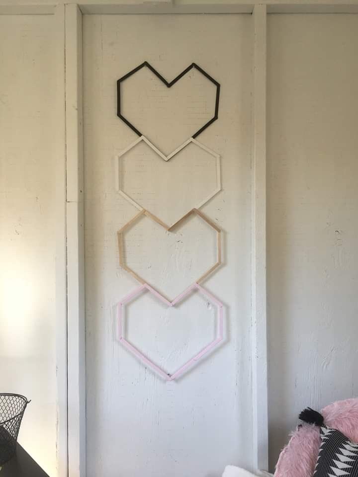 three hexagonal shapes are hanging on the wall next to a black and white chair