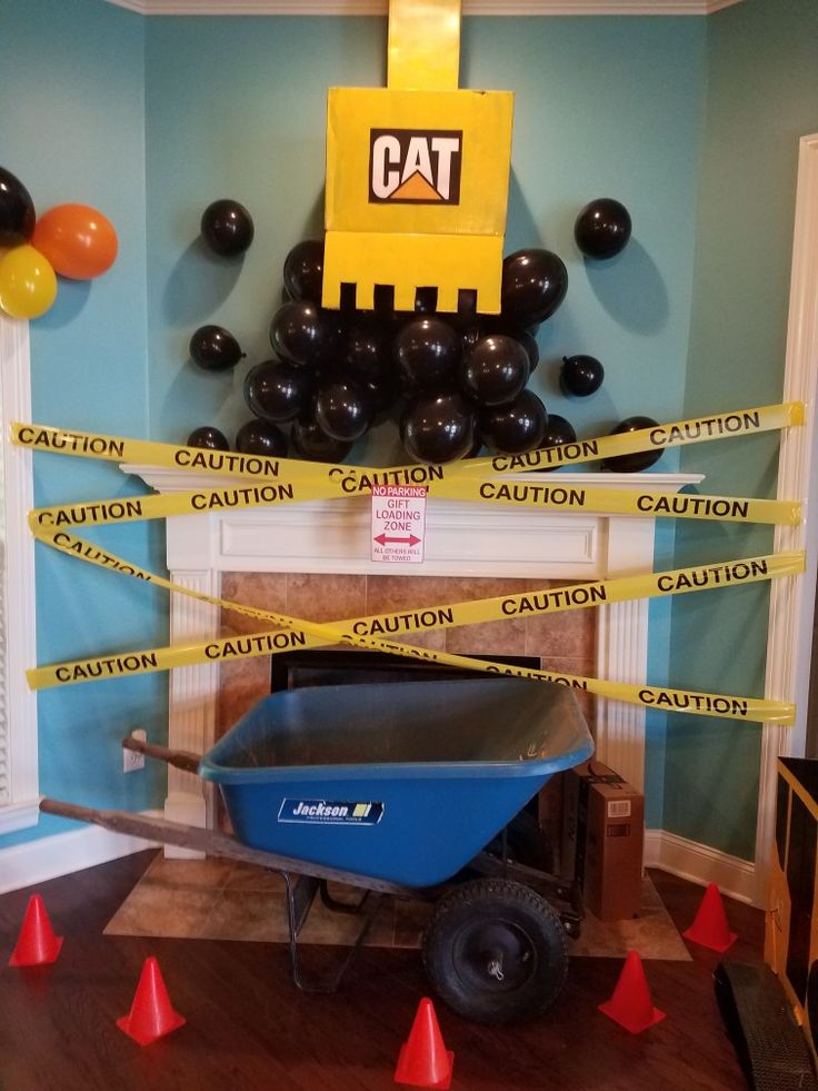 a blue wheelbarrow with caution tape around it in front of a cat sign