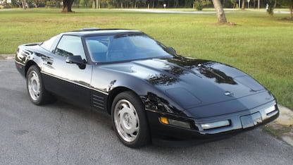 a black sports car is parked on the street