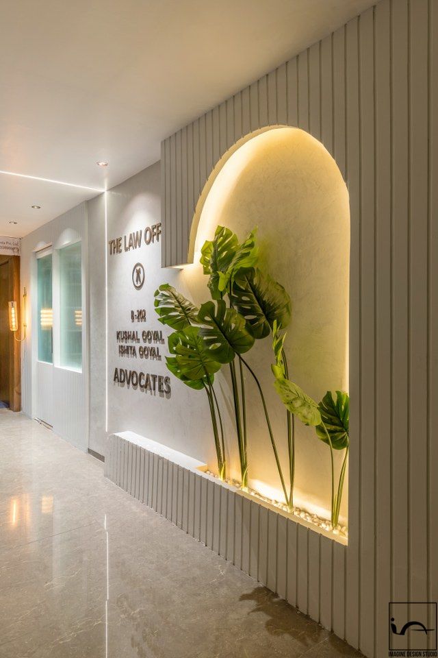 the interior of an office building with plants growing on the wall and signage above it