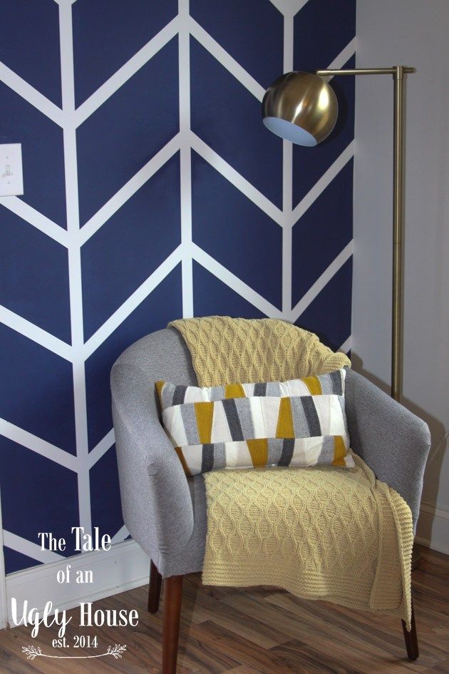 a chair with a blanket on it in front of a wall painted blue and white