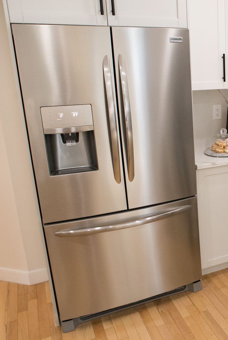 a stainless steel refrigerator in a white kitchen