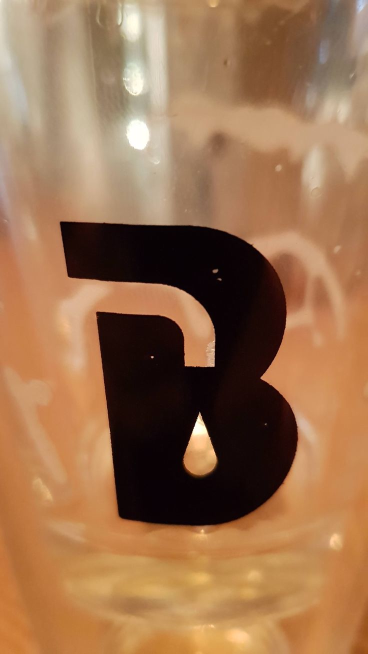 the letter b is cut out on top of a plastic cup with water in it