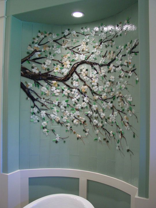 a bathroom wall decorated with white flowers and branches in the shape of a tree is shown