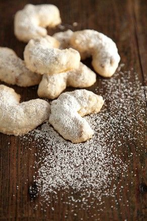 powdered sugar coated pastries sitting on top of a wooden table