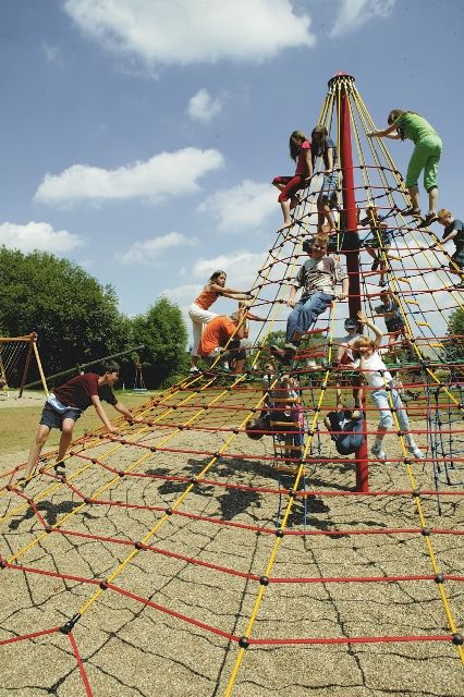 children playing on a playground structure with ropes