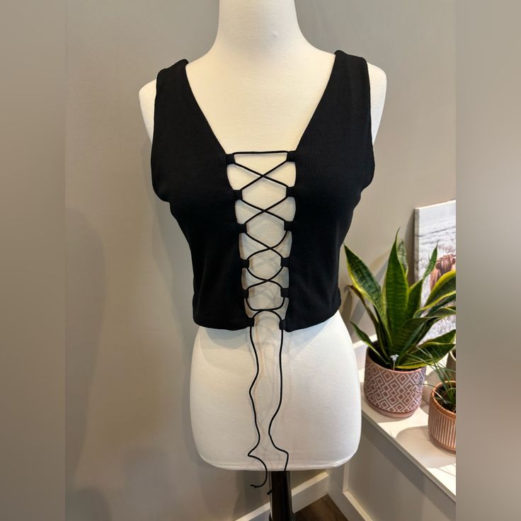 Black Lace Up Tank Top Size L Condition- Never Worn Tied Up For A Little Cleavage, Or Leave It Untied For More Cleavage Black Tie Back Crop Top, Black Tie Back Crop Top For Spring, Black Tie-back Crop Top For Spring, Black V-neck Top With Tie Back, Black Cross-tied Top For Spring, Black Cross-tied Top For Summer, Lace Up Tank Top, Black Tank Top, Black Tank