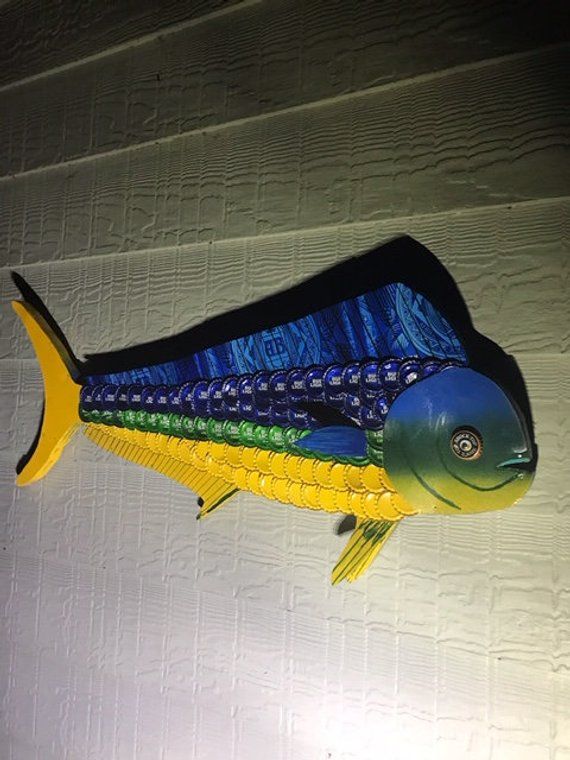 a blue and yellow fish hanging from the side of a building