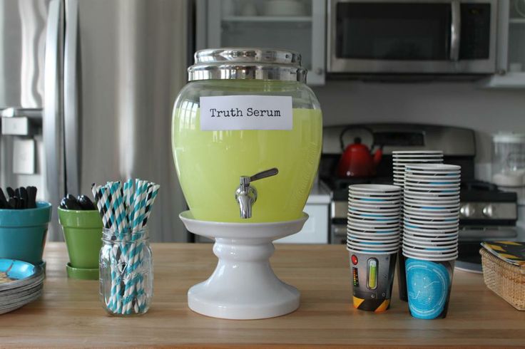 a kitchen counter topped with lots of plates and cups next to an ice cream dispenser