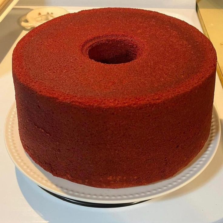 a red cake sitting on top of a white plate