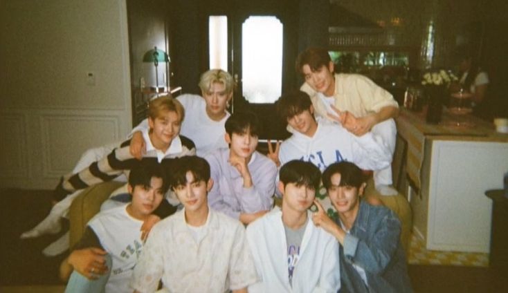 a group of young men sitting next to each other in front of a kitchen counter