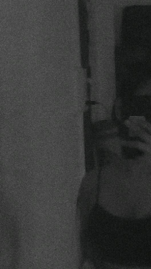 black and white photograph of a woman taking a selfie with her cell phone in the mirror