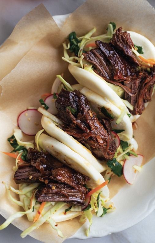 some food is on a white plate and has lettuce, carrots, and meat in it