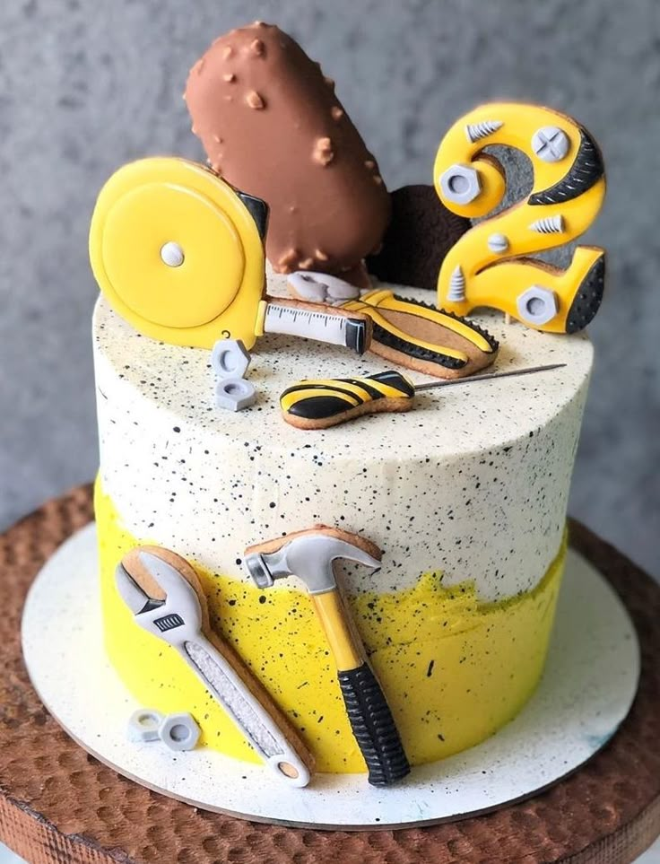 there is a cake that has construction tools on it and the icing is yellow