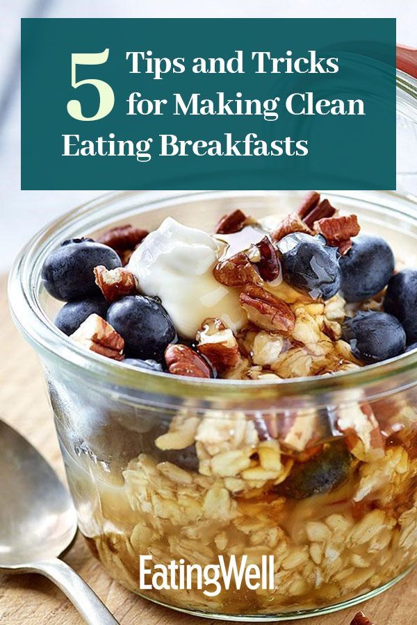 a glass bowl filled with granola and blueberries on top of a wooden table