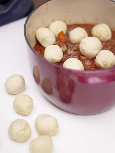 a pot filled with dumplings sitting on top of a table next to other items