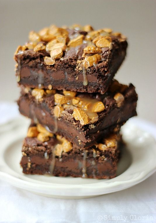 three brownies stacked on top of each other with peanut butter and chocolate toppings