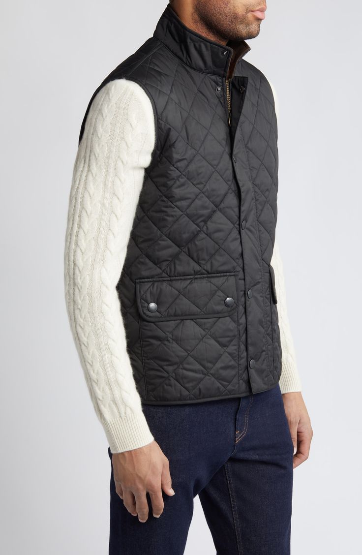 This sleek, diamond-quilted vest detailed with oversized flap pockets is a layering essential for the season and offers warmth, versatility and style. 27 1/2" length (size Medium) Front snap closure Stand collar Front snap-flap patch pockets Lined, with polyester fill 100% polyester Machine wash, line dry Imported Classic Diamond Quilted Jacket For Winter, Classic Winter Quilted Jacket With Diamond Quilting, Classic Sleeveless Outerwear For Outdoor, Black Quilted Sleeveless Vest, Classic Black Quilted Jacket For Work, Sleeveless Quilted Black Outerwear, Classic Quilted Outerwear For Cold Weather, Black Cable Knit Outerwear For Work, Quilted Sleeveless Vest For Workwear