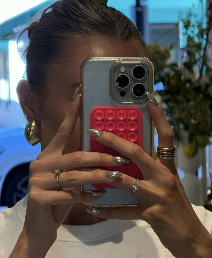 a woman taking a selfie with her cell phone in front of her earring