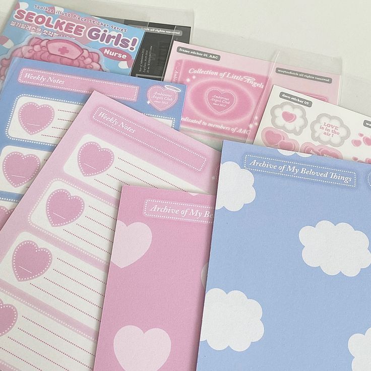 several notebooks with hearts and clouds on them