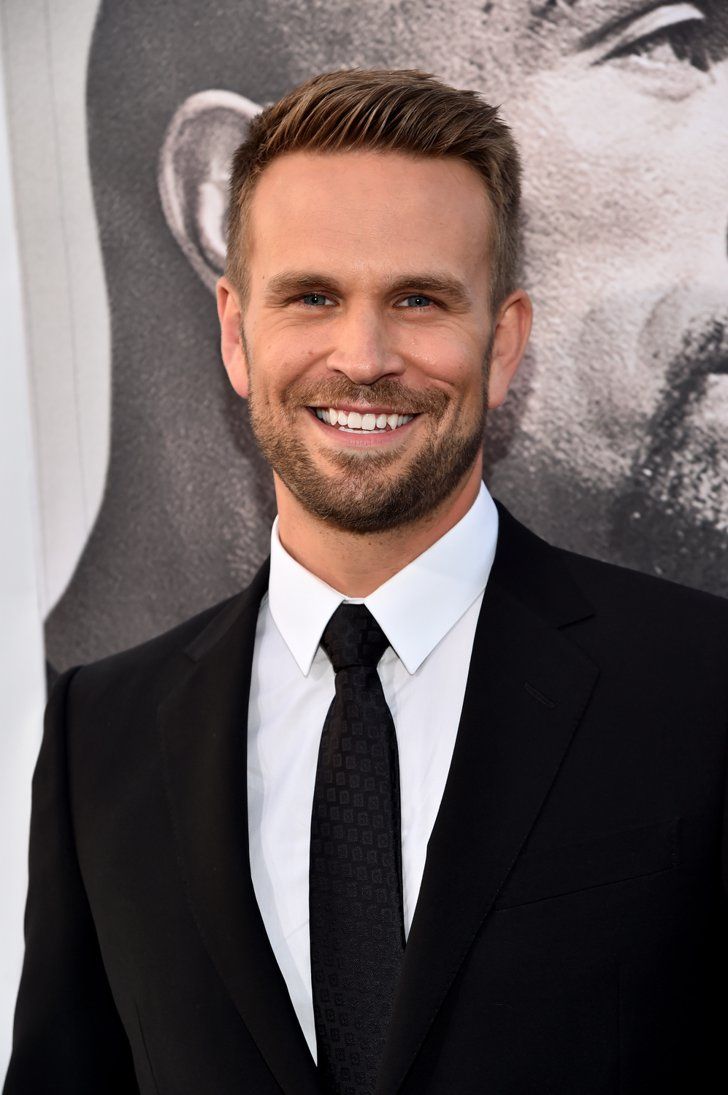 a man in a suit and tie smiling at the camera