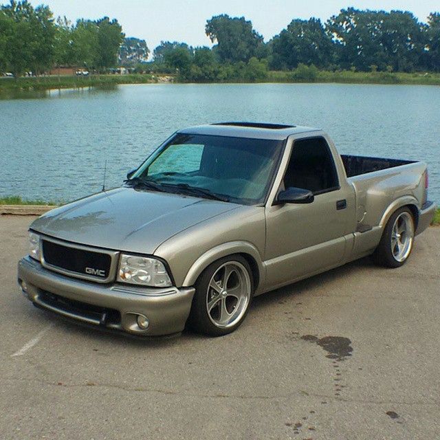 a silver pick up truck parked next to a lake