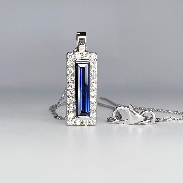 "Baguette Shaped Blue Sapphire Pendant Necklace 14K Gold , Long Blue Sapphire Necklace , Dainty Layering Necklace September Birthstone to revisit our store click here: https://etsy.me/3Pzzwpx for blue sapphire rings click here: https://etsy.me/3U6sHvD for more pendant options click here: https://etsy.me/3AKsPsY The pendant pictured is a lab created sapphire #8284 Available with lab created ruby, emerald, blue saph or olive green saph center Diamond or moissanite halo Use dropdown to make selecti Sapphire Pendant Necklace With Accent Stones, Sapphire Necklace Baguette Cut For Gift, Pendant Necklace With Sapphire In Diamond Cut, Sapphire Pendant Necklace With Diamond Cut, Sapphire Gemstone Jewelry With Rectangular Pendant, Sapphire Pendant Necklace, Dainty Necklace Layered, Sapphire Necklace Pendants, Blue Sapphire Pendant