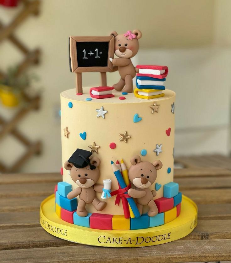 a birthday cake with teddy bears on top and a chalkboard in the back ground