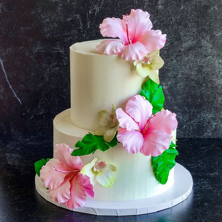 Three tier buttercream wedding cake decorated with sugar hibiscus, orchids and palm leaves Hibiscus Wedding Cake, Hibiscus Cake Decoration, Tropical Cake Ideas, Hibiscus Flower Cake, Tropical Flower Wedding, Hawaiian Theme Cakes, Luau Centerpieces, Hawaiian Birthday Cakes, Hibiscus Cake