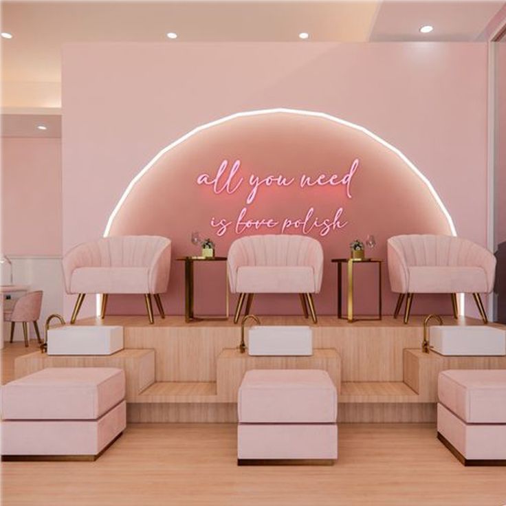 a salon with pink chairs and neon signs on the wall behind them that says, all you need is love not hate