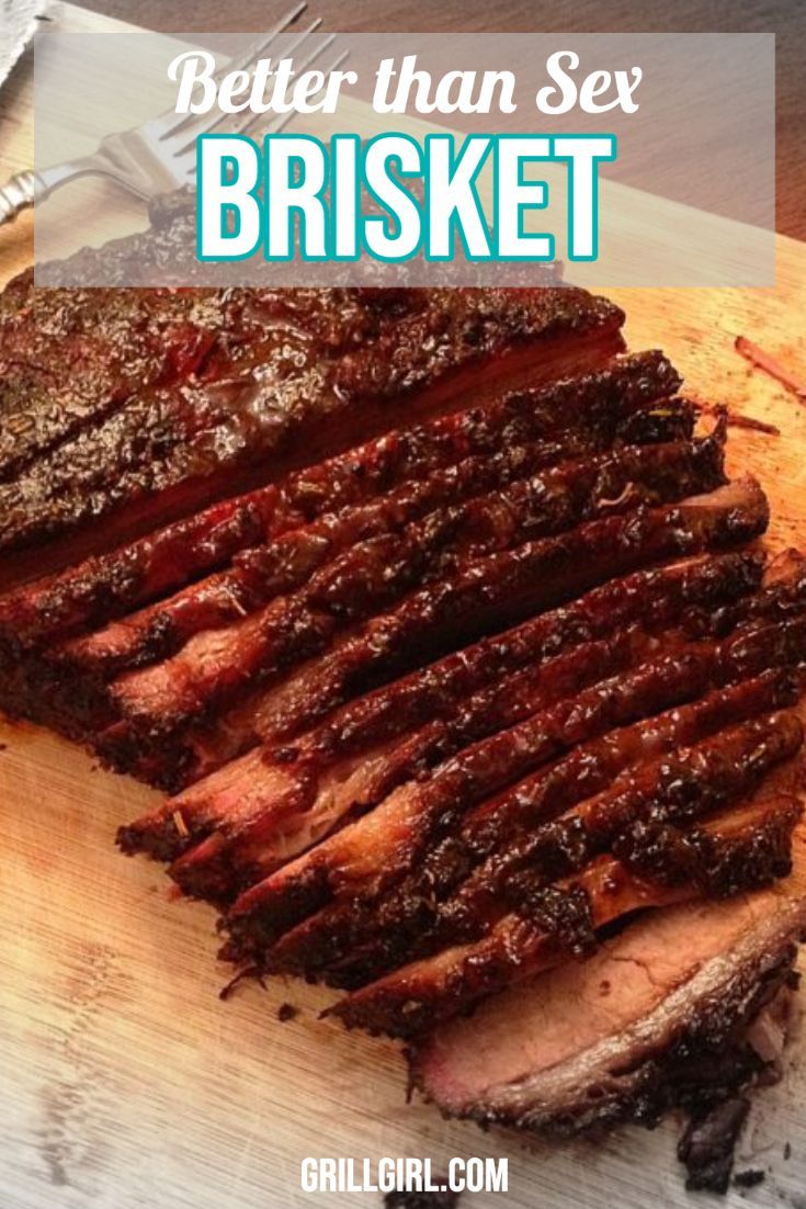 sliced brisket sitting on top of a cutting board next to a knife and fork