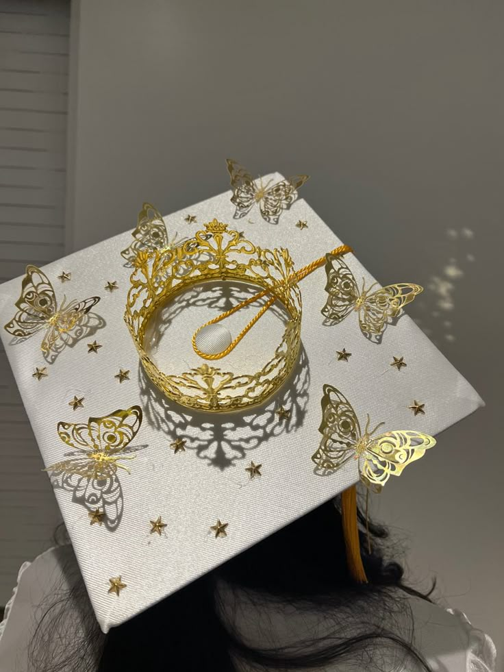 a graduate's cap with butterflies on it and the words graduation written in gold