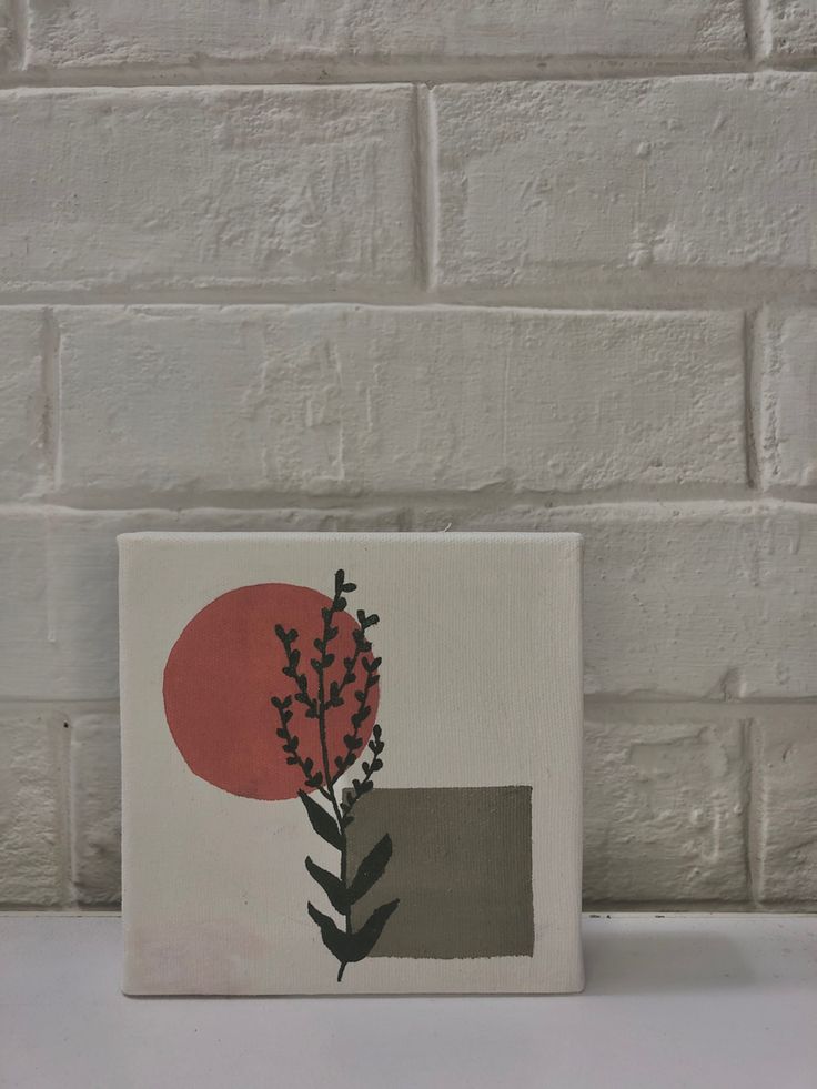 a painting on a white brick wall with a red sun in the background and some black leaves