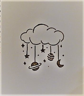 a notebook with an image of clouds and planets hanging from the strings on it's side