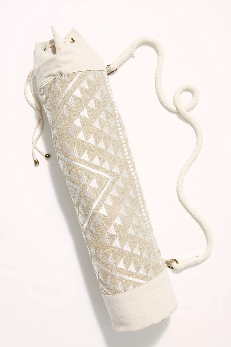 a white bag with an intricate design on the front and side, hanging from a string